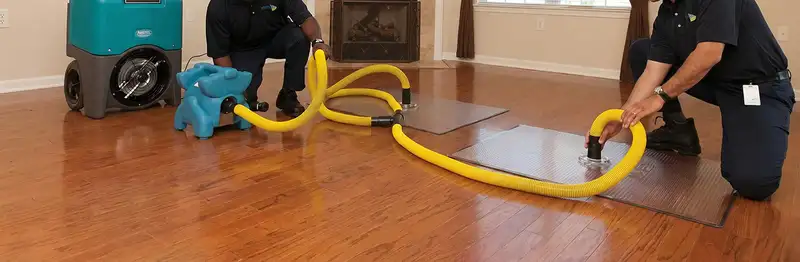 emergency water removal technicians extracting standing water from a home using professional equipment in Atlanta, GA